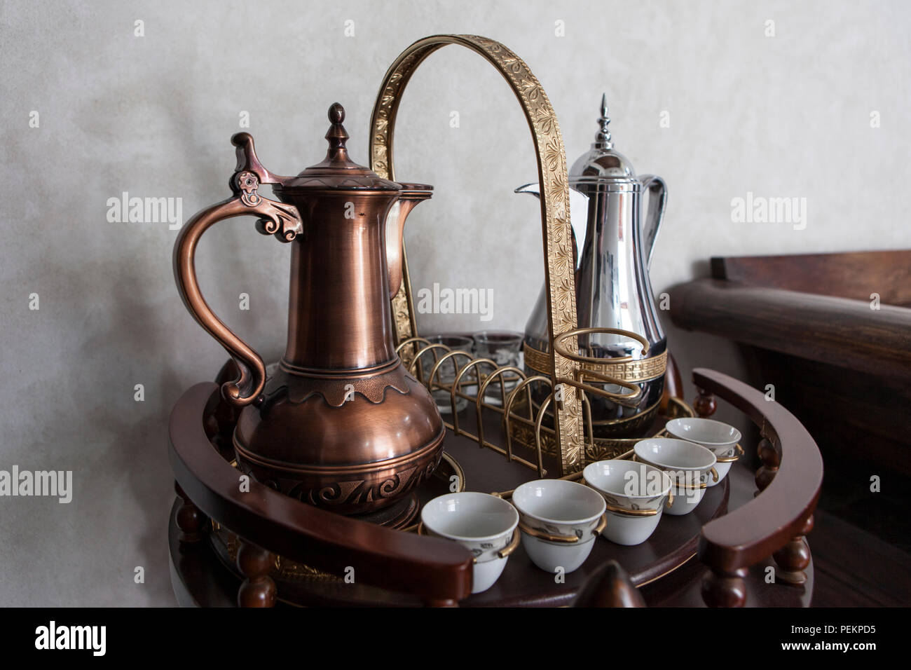 Due tradizionali caffè arabo pentole, con coppe di accompagnamento, Dubai, Emirati Arabi Uniti Foto Stock