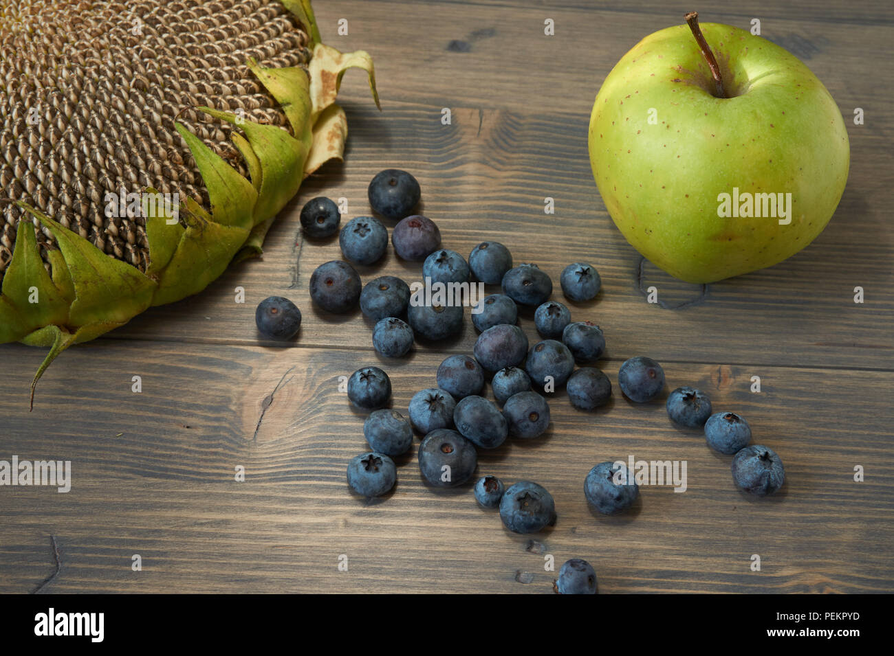 More, apple e testa di girasole su un legno rustico sfondo in una vita sana dieta nutritiva concetto con libero spazio di copia Foto Stock