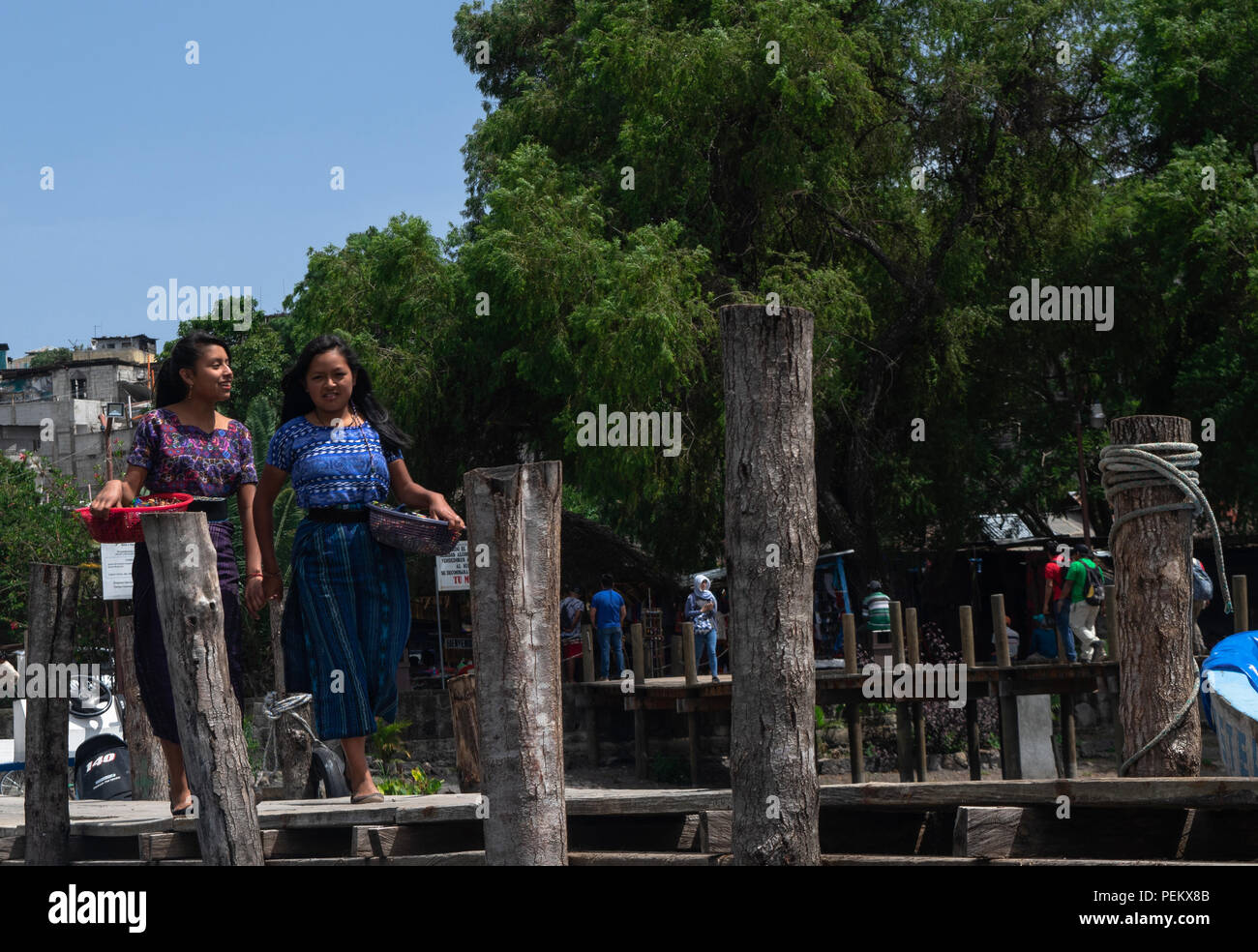 Le giovani ragazze con ceste piene di souvenir a vendita al turista avvicinando lago Atitlan dock. Luglio 14, 2018 Foto Stock