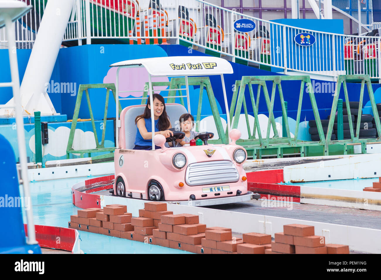 TOKYO, Giappone - 19 Luglio 2016 - mamma giapponese e sua figlia di godere del loro tempo insieme a cavallo su un Furi Furi GP auto presso il Tokyo Dome City Amusement Park i Foto Stock