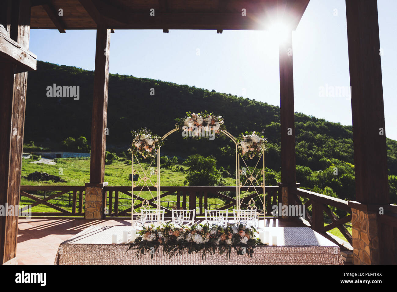 Splendidamente decorate ricevimento di nozze all'aperto sulla terrazza grande. Tavoli bianchi e arco di fiori nella luce solare Foto Stock