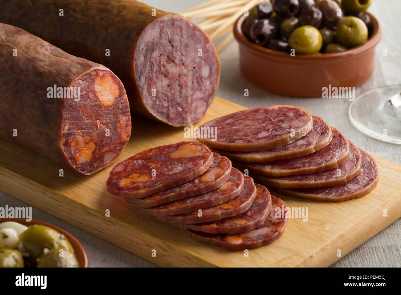 Pezzo tradizionale di spagnolo Salchichon salsiccia, il chorizo, fette e olive close up Foto Stock