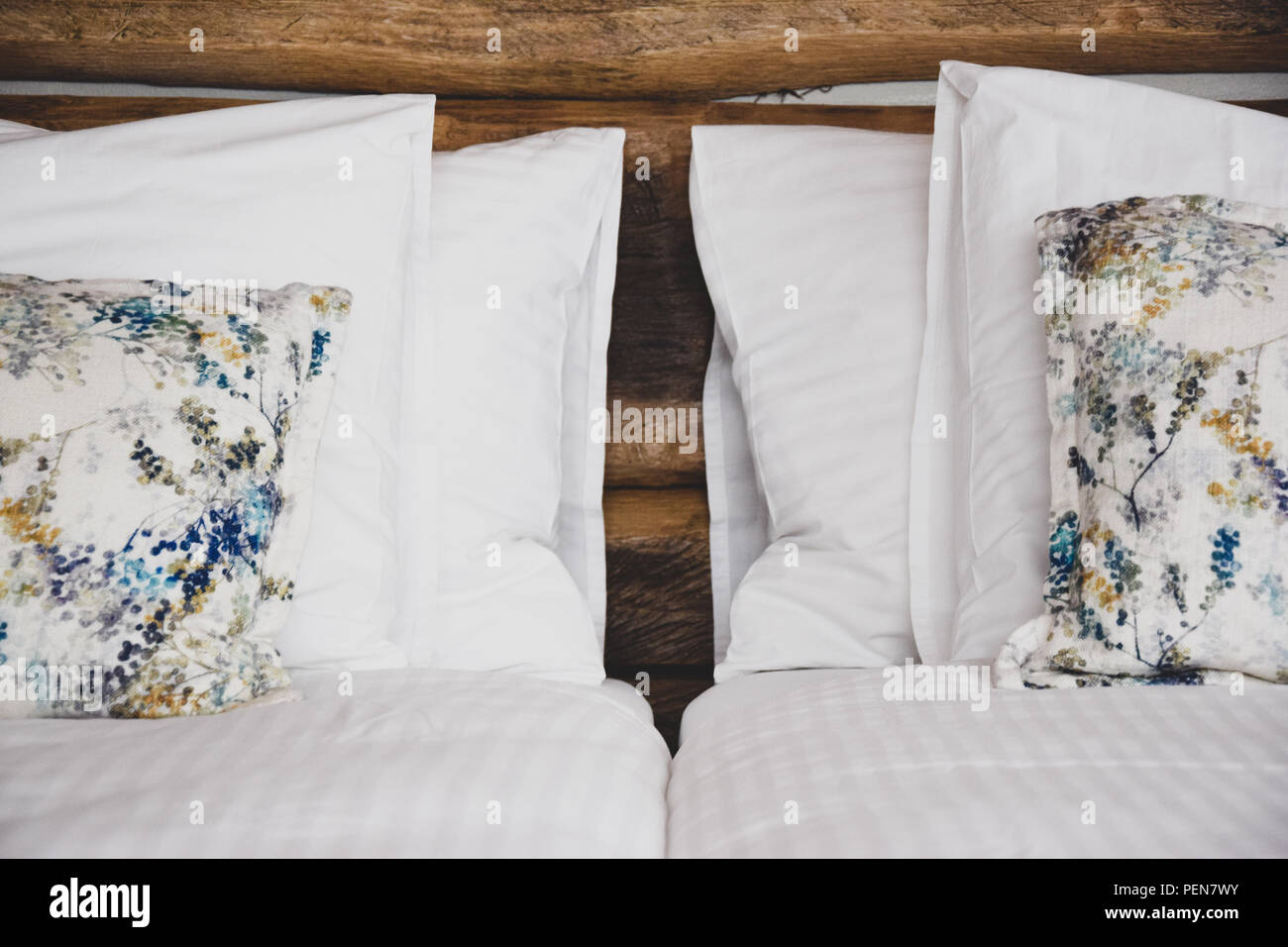 Interni della camera da letto, interni confortevoli e confortevoli, con un letto matrimoniale appena rifatto con lenzuola bianche e una testata con cuscino Foto Stock