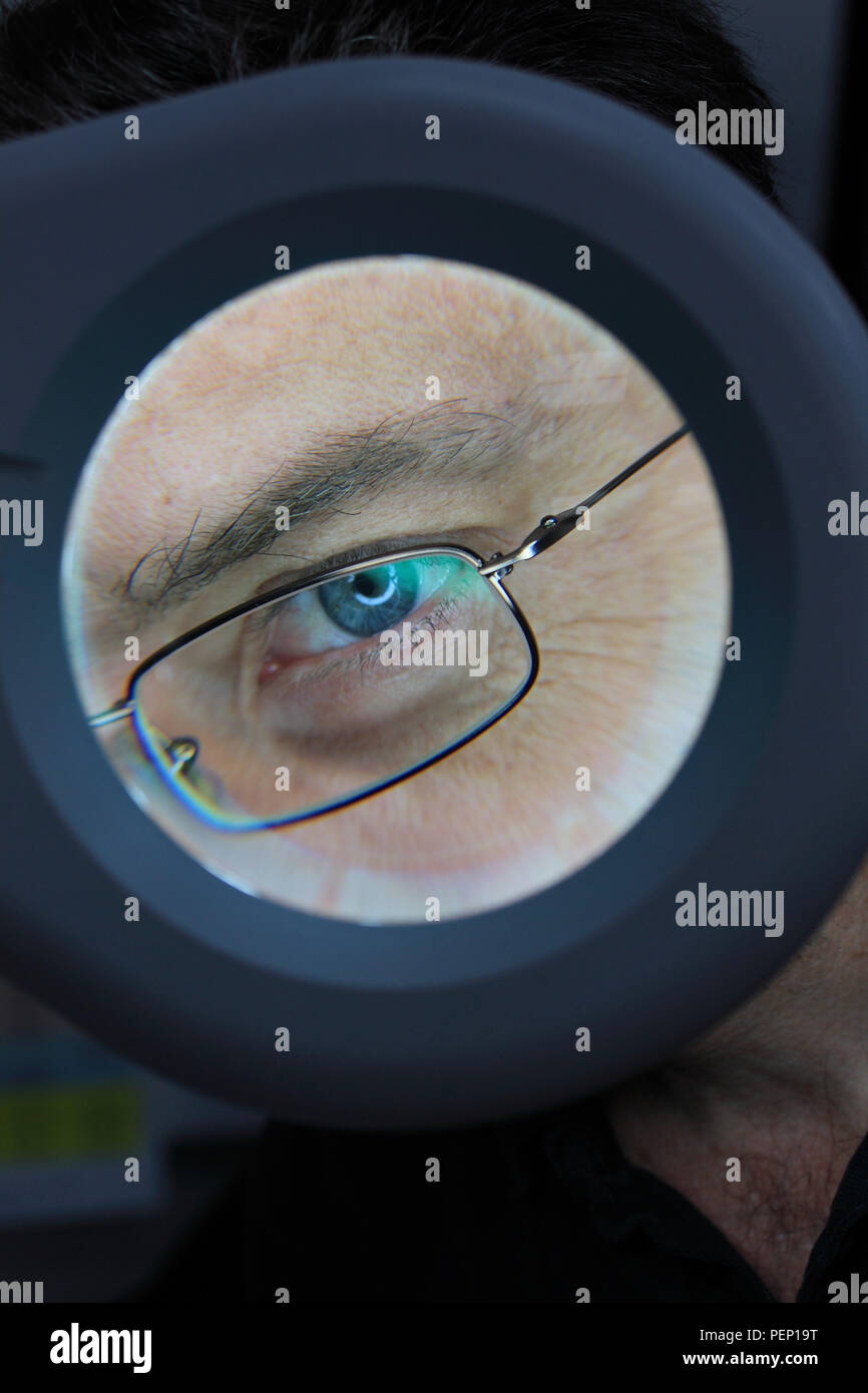 Primo piano della occhio visto attraverso la lente di ingrandimento Foto Stock