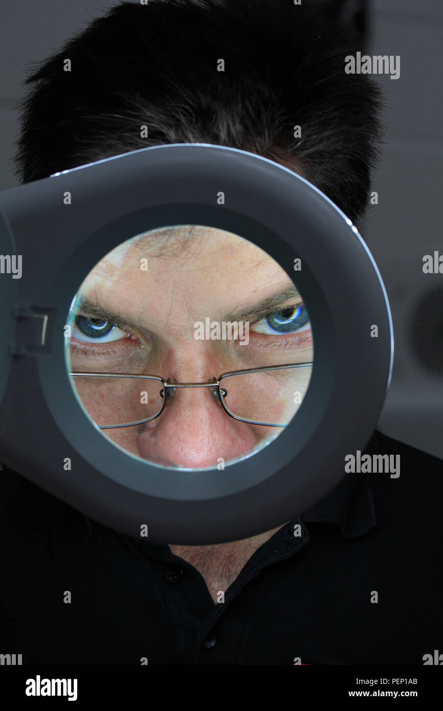 Primo piano della occhio visto attraverso la lente di ingrandimento Foto Stock