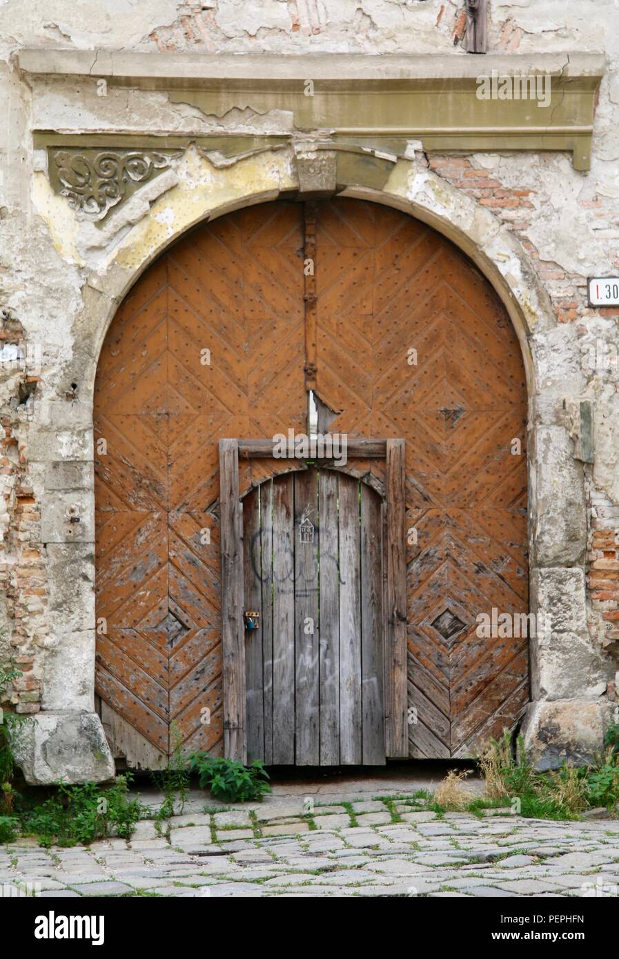 Una vecchia porta di legno su un edificio condannato in Europa Foto Stock