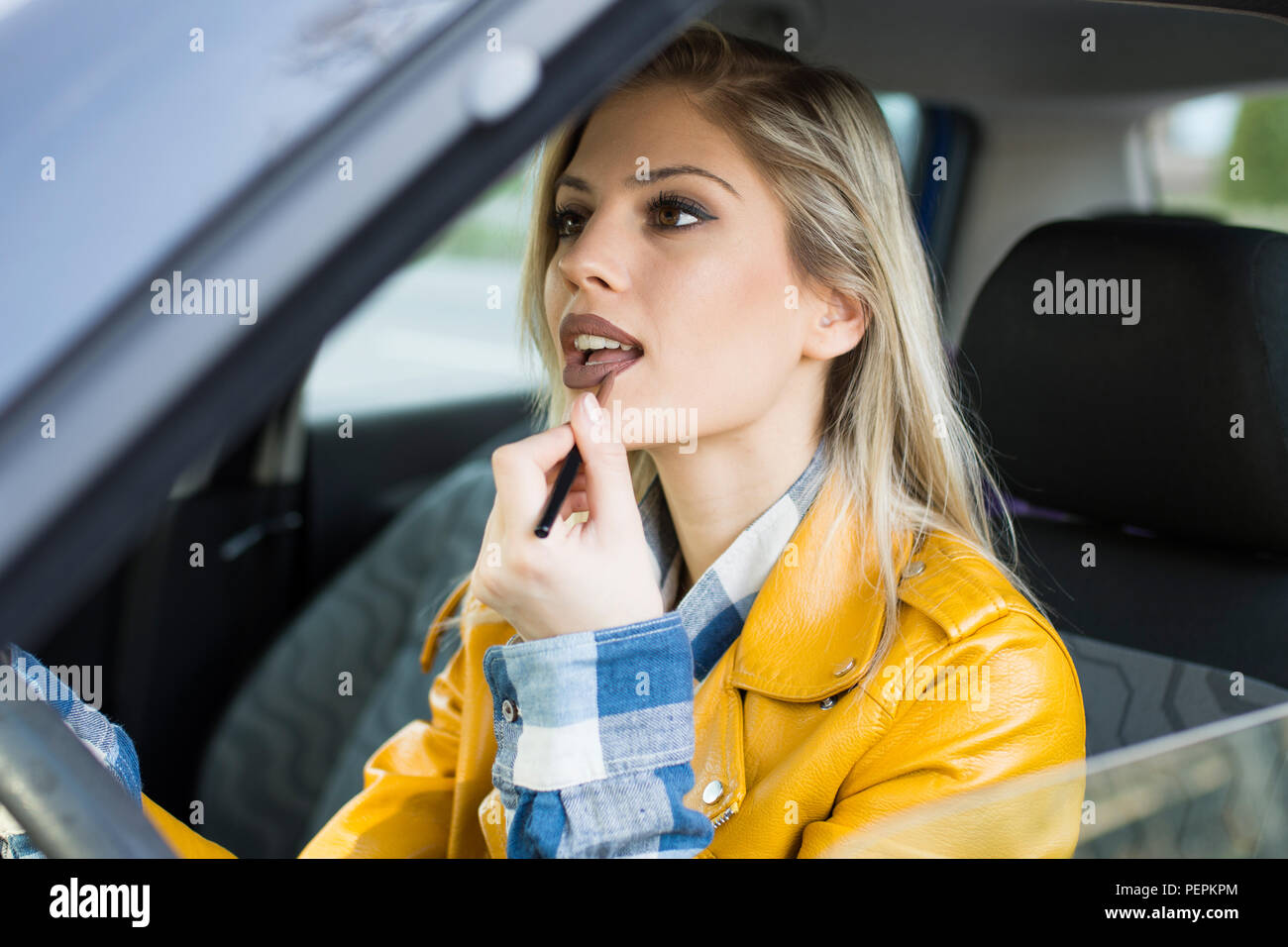 Bella donna fare il trucco in auto Foto Stock