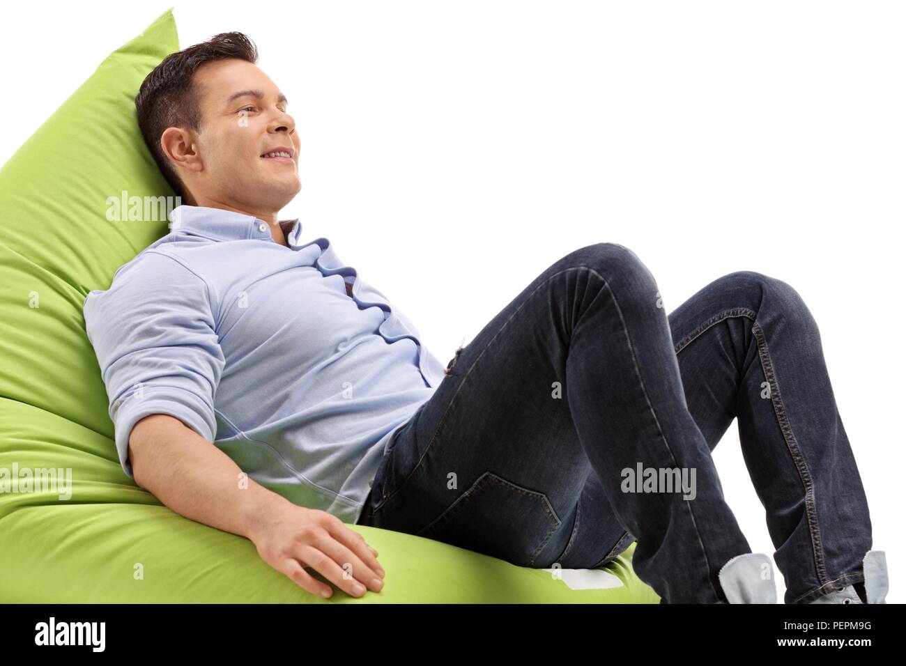Giovane uomo seduto su un beanbag isolati su sfondo bianco Foto Stock