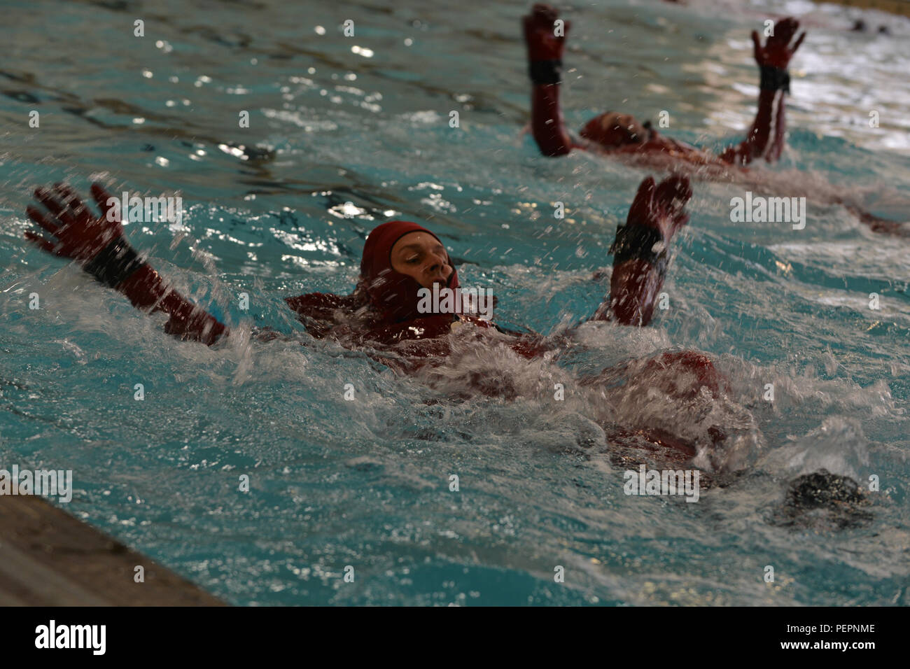 Esercito degli Stati Uniti PFC. Anthony Rhodes, un natante operatore studente con il trasporto intermodale marittimo Training Department, nuota accanto a compagni di classe durante una sopravvivenza corso di nuoto a Fort Eustis, Virginia, Gennaio 26, 2016. Gli studenti abbiamo nuotato in tute di sopravvivenza, che agiscono come galleggiamento e dispositivi termici. (U.S. Air Force photo by Staff Sgt. Natascia Stannard) Foto Stock