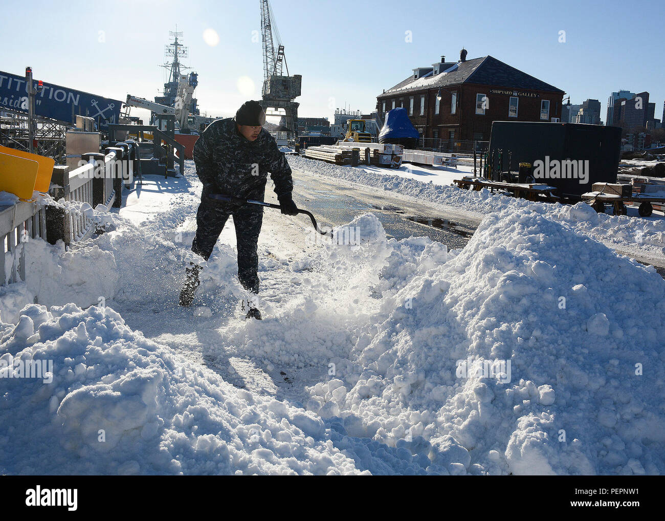 Marinaio Darion Delaney, da Dayton, Ohio, pale neve accanto alla USS Constitution in Charlestown Navy Yard Gen 24, 2016 dopo il primo inverno tempesta del 2016. Costituzione è attualmente in bacino di carenaggio uno in Charlestown Navy Yard mentre lei riceve le riparazioni per il suo scafo e framework. (U.S. Foto di Marina di Massa Specialista comunicazione marinaio Mickey Treigle/rilasciato) Foto Stock