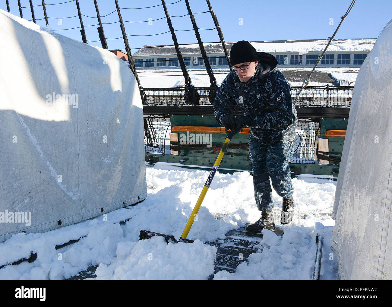 Nave veterani della Seconda Classe Justin Howard, da Phoenix, spinge la neve a bordo della USS Constitution Gen 24, dopo il primo inverno tempesta del 2016. Costituzione è attualmente in bacino di carenaggio uno in Charlestown Navy Yard mentre lei riceve le riparazioni per il suo scafo e framework. (U.S. Foto di Marina di Massa Specialista comunicazione marinaio Mickey Treigle/rilasciato) Foto Stock