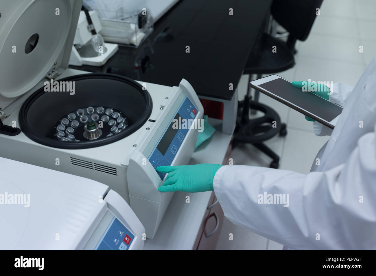 Tecnico di laboratorio utilizzando centrifuga refrigerata macchina Foto Stock