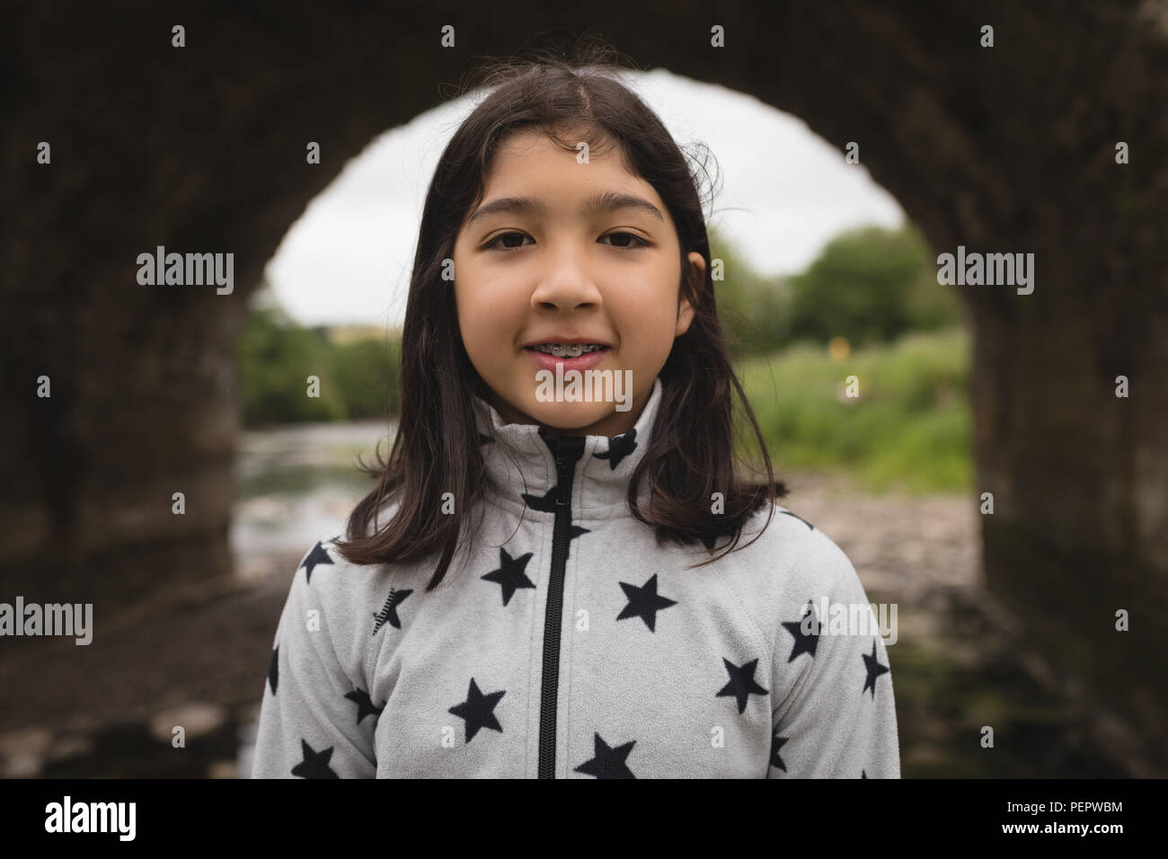 Ragazza sorridente vicino a Riverside Foto Stock