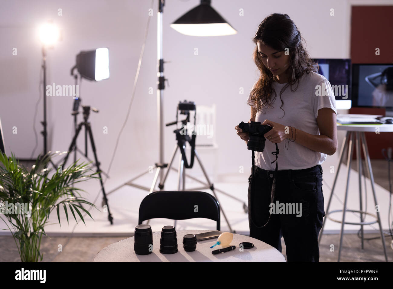 Modello femminile rivedendo le foto sulla fotocamera digitale Foto Stock