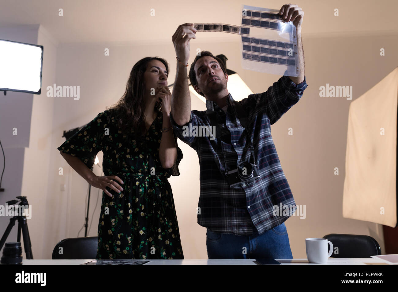 Fotografo maschio e femmina modello guardando filmina negativa Foto Stock