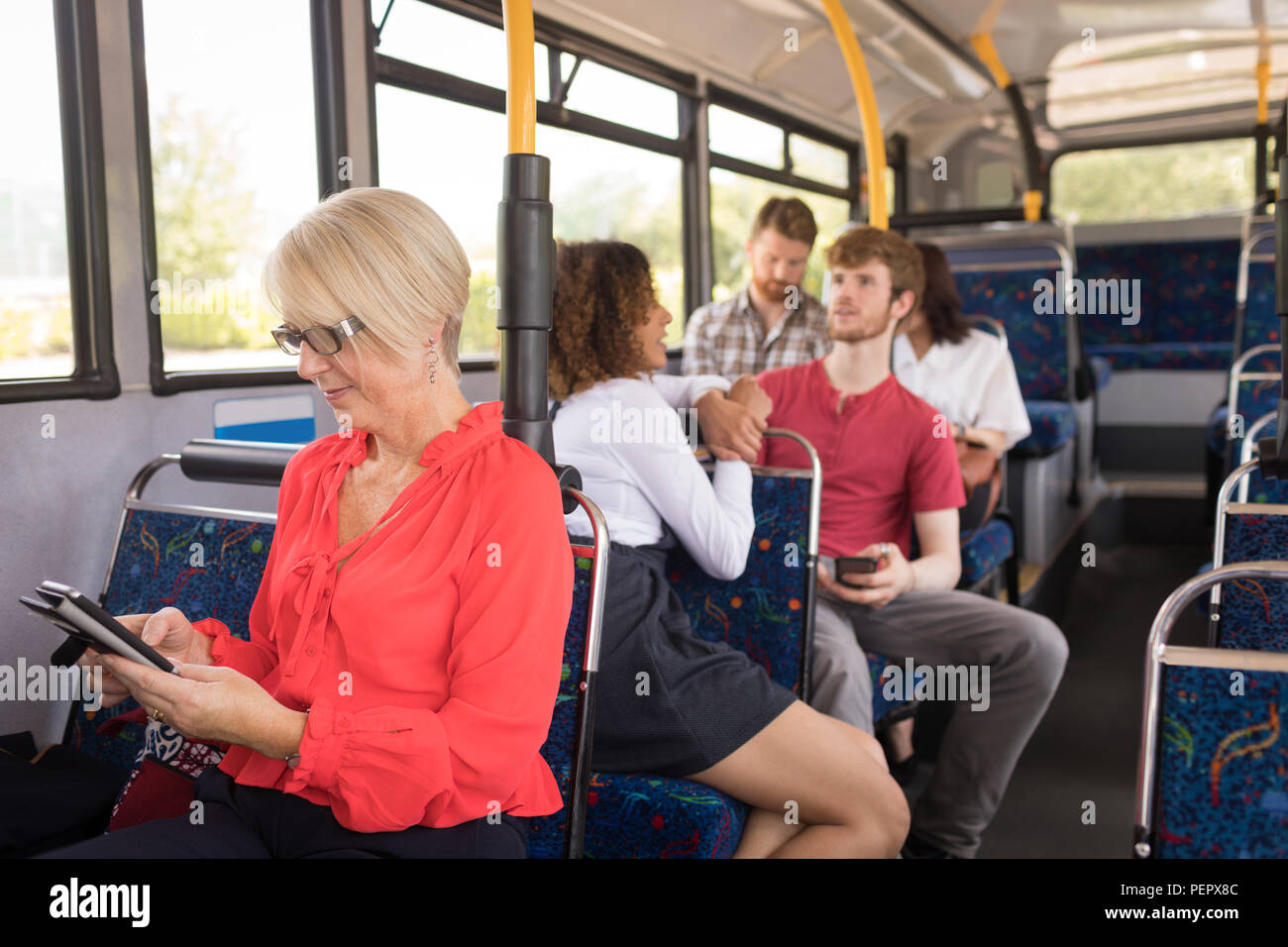 Di " commuters " femmina utilizzando il telefono cellulare mentre si è in viaggio in bus Foto Stock