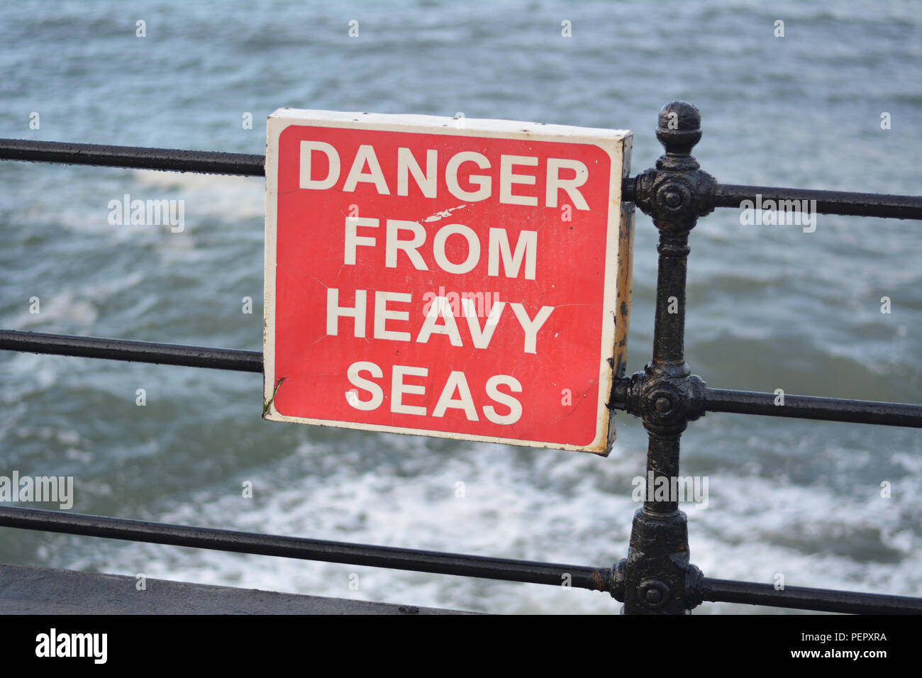 Metallo rosso segno di avvertimento pericolo da pesanti mari a Scarborough lungomare Foto Stock