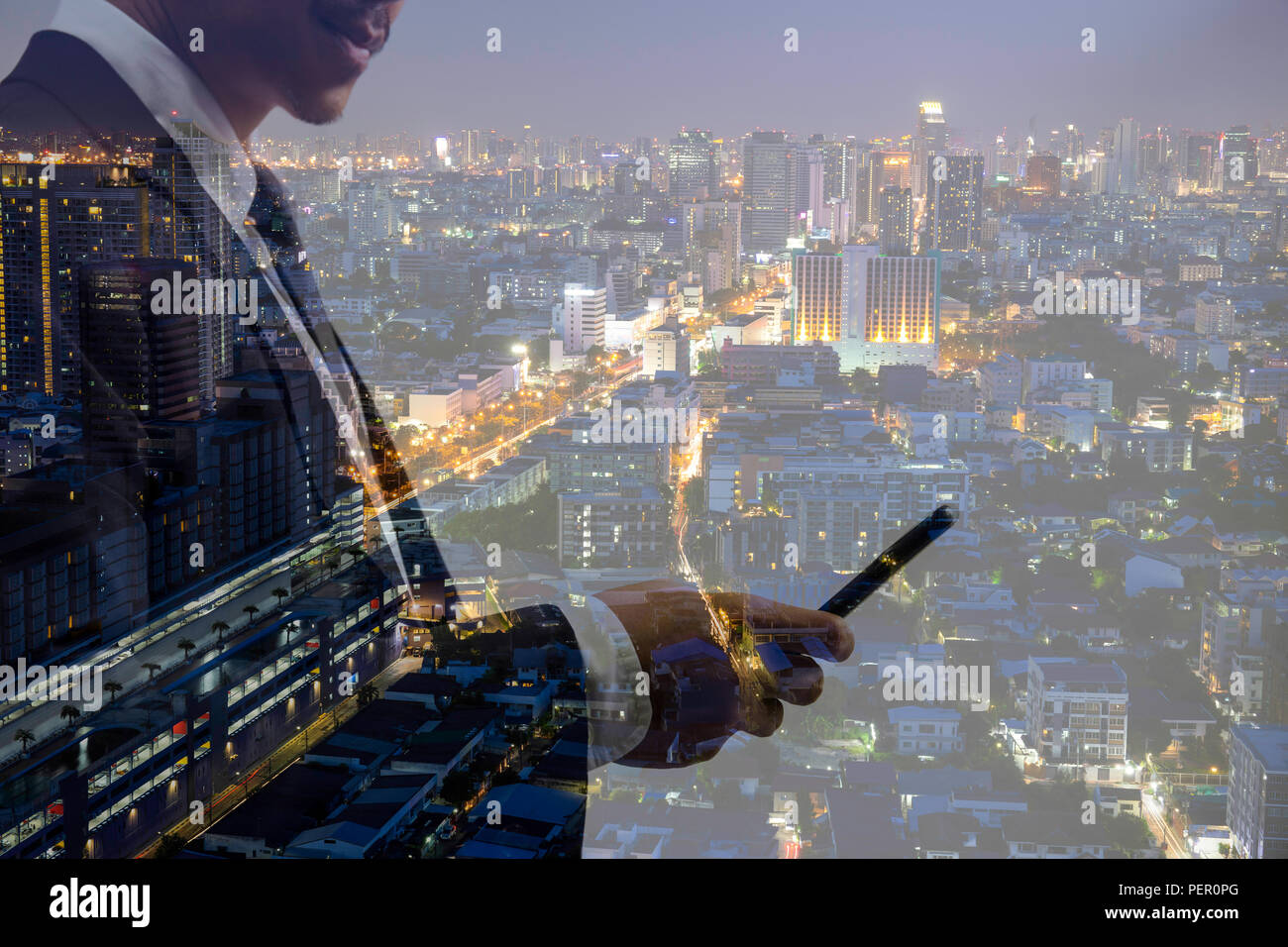 La doppia esposizione imprenditore tramite telefono cellulare con city building in background durante la notte. Foto Stock