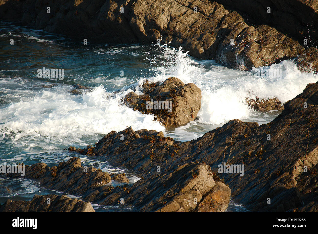 Onde che si infrangono sulle rocce sulla North Devon (UK) costa. Foto Stock