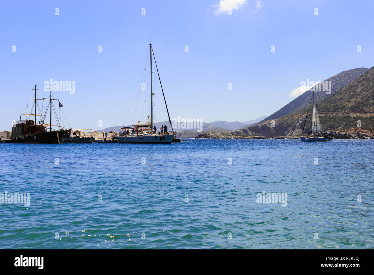White in barca a vela in mare aperto. Sailing yacht in mare aperto con le montagne sullo sfondo. Foto Stock