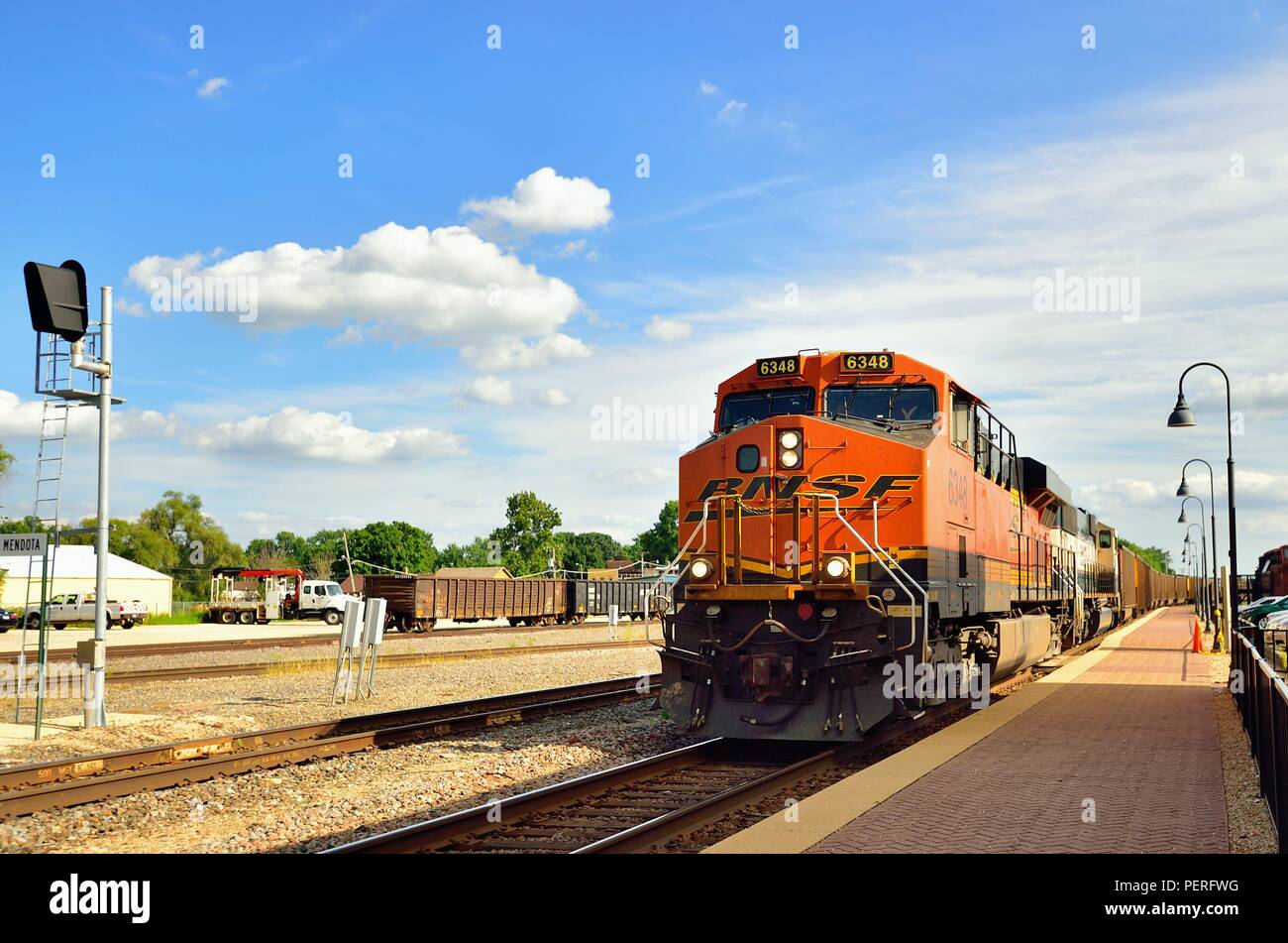 Mendota, Illinois, Stati Uniti d'America. Un easbound Burlington Northern Santa Fe treno di unità del vuoto del carbone vetture rumbling attraverso Mendota sul suo viaggio a Chicago. Foto Stock