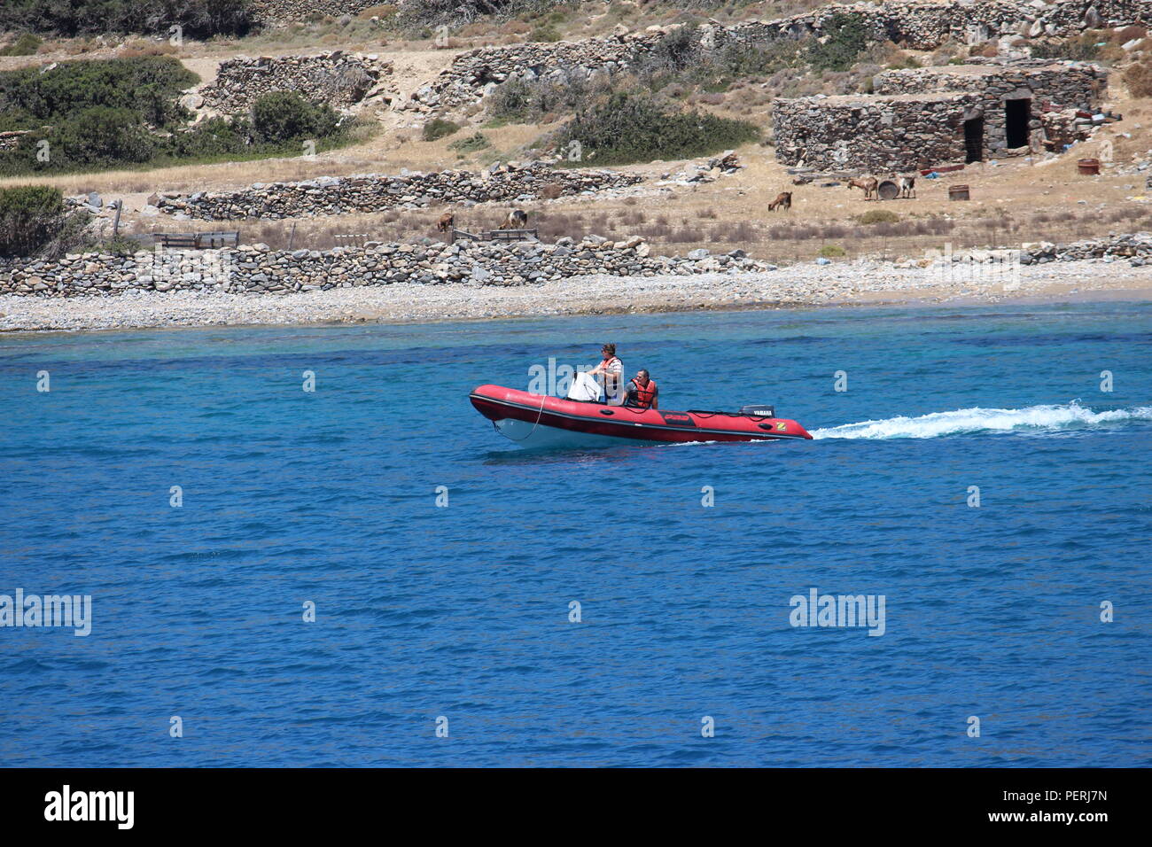 Imbarcazione a motore lungo una costa rocciosa nel Mare Egeo Foto Stock