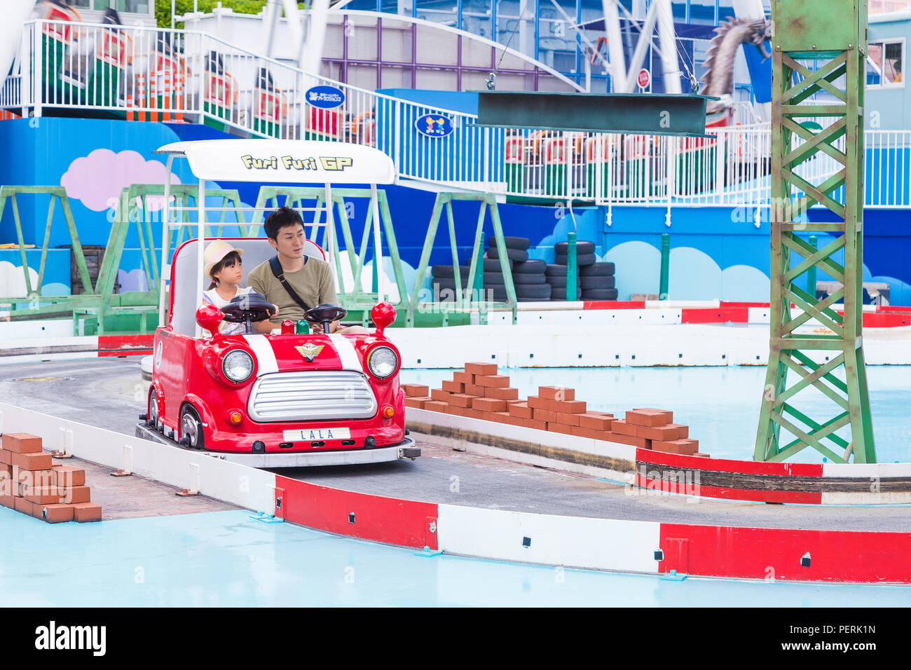 TOKYO, Giappone - 19 Luglio 2016 - Giapponese papà e sua figlia godere del loro tempo insieme a cavallo su un Furi Furi GP auto presso il Tokyo Dome City Amusement Park i Foto Stock