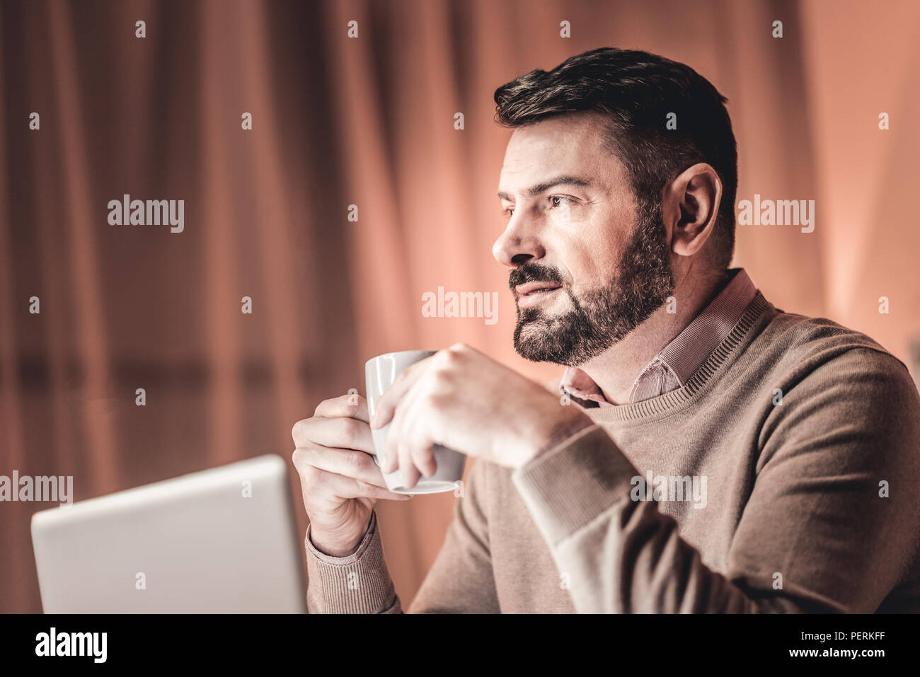 Considerato il brainstorming uomo seduto accanto al laptop Foto Stock