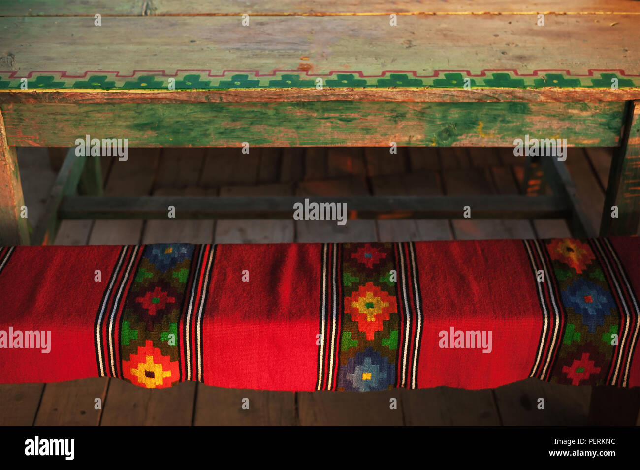 Il decor di un tappeto artigianale realizzato in Serbia su una panca in legno. Villaggio Tradizionale stile di vita. Foto Stock