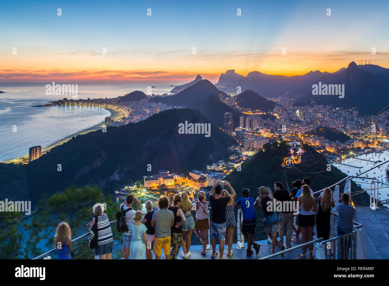 I turisti la visualizzazione di Cristo redentore sul monte Corcovado e la città al tramonto dalla Sugarloaf (Pao de Acucar) a Rio de Janeiro in Brasile Foto Stock