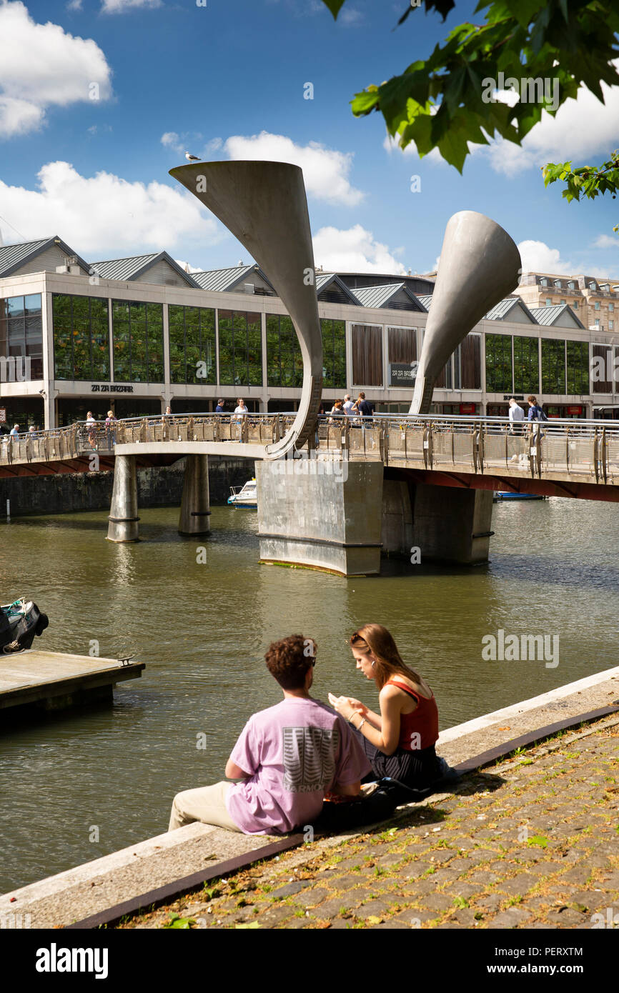 Regno Unito, Inghilterra, Bristol, porto, giovane seduto sulle strette Quay a Pero's Bridge Foto Stock