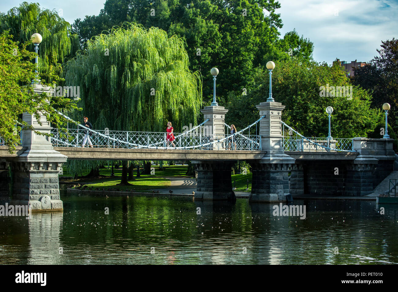 Persone attraversando ponte sul laghetto, giardino pubblico, Boston, Massachusetts, STATI UNITI D'AMERICA Foto Stock