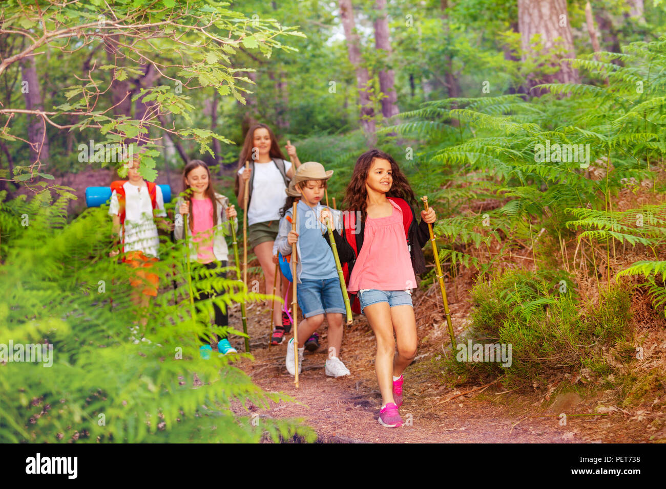 Gruppo di bambini passeggiate nella foresta sulla scuola attività estiva una dopo l altra e zaini Foto Stock