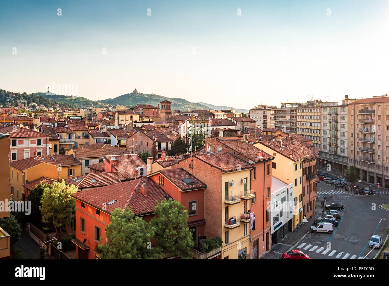 Bologna, Emilia Romagna, Italia. I tetti della città al tramonto: Basilica di San Luca sullo sfondo. Foto Stock