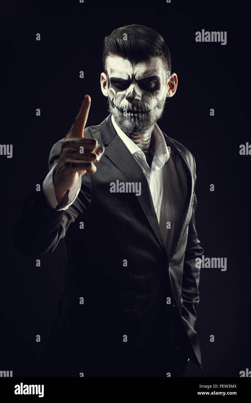 Ritratto di uomo con teschio Halloween trucco sulla backgro nero Foto Stock