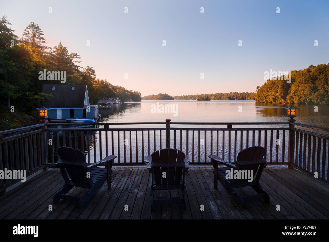 Trio di Muskoka sedie su un patio che si affaccia sul Lago di Giuseppe all'alba. Foto Stock