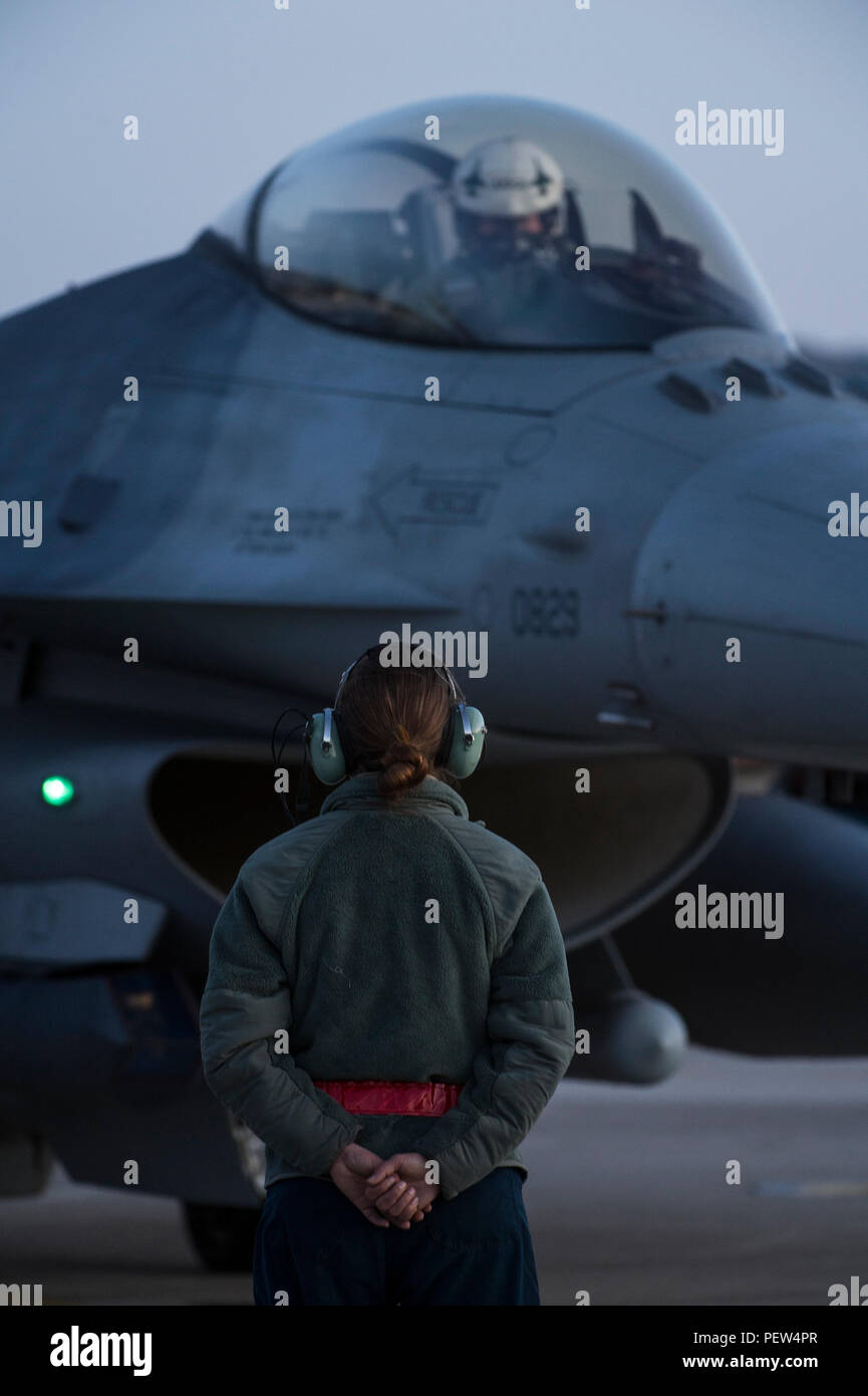 Un U.S. Air Force capo equipaggio assegnati alla Expeditionary 480th Fighter Squadron attende al segnale di andare avanti per taxi un F-16 Fighting Falcon pilota durante una missione di addestramento a Souda Bay, Grecia, Feb. 1. 2016. Circa 300 personale e 18 F-16s dal 52nd Fighter Wing a Spangdahlem Air Base, Germania, ci sono il supporto di una formazione di volo la missione come parte degli Stati Uniti Forze Aeree in forze Europe-Air in Africa la 'Avanti Ora pronto' atteggiamento. (U.S. Air Force photo by Staff Sgt. Christopher Ruano/rilasciato) Foto Stock
