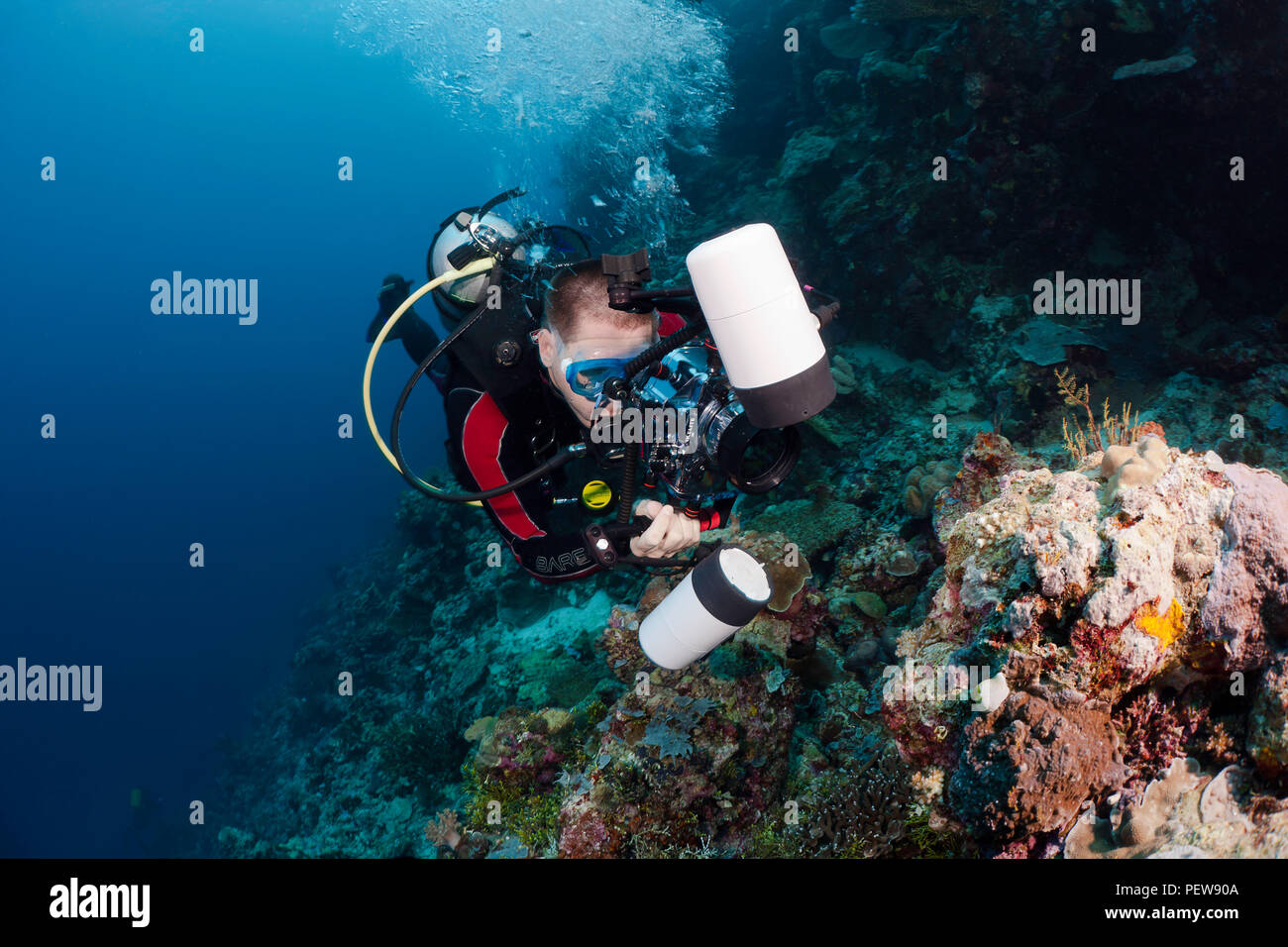 Un subacqueo le riprese di una reflex digitale di linee su una barriera corallina indonesiana. Il subacqueo è il modello rilasciato. Foto Stock