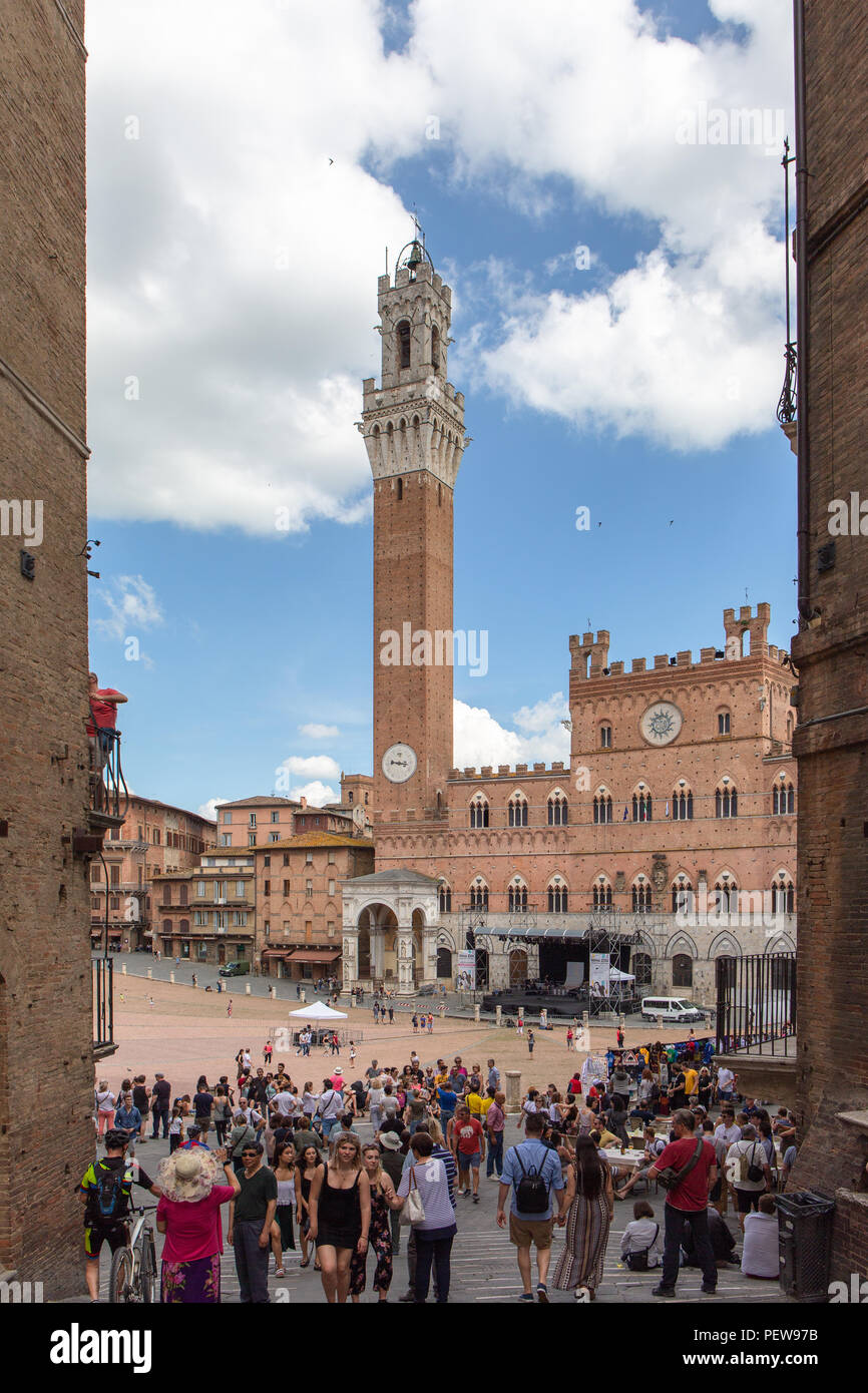 Siena, Italia. I turisti in Piazza del Campo con la Torre del Mangia. Foto Stock
