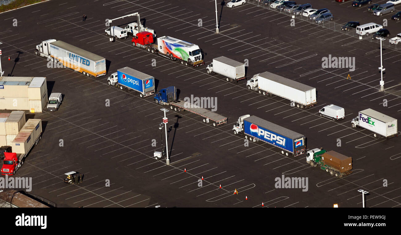 Linea di carrelli fino a un parcheggio per essere radiografato da un U.S. Delle dogane e della protezione delle frontiere non intrusivo veicolo di ispezione, in alto a sinistra, in quanto essi forniscono beni a Levi's Stadium, il sito del Super Bowl 50, in Santa Clara, California, 2 febbraio, 2016. (CBP Foto di Glenn Fawcett) Foto Stock