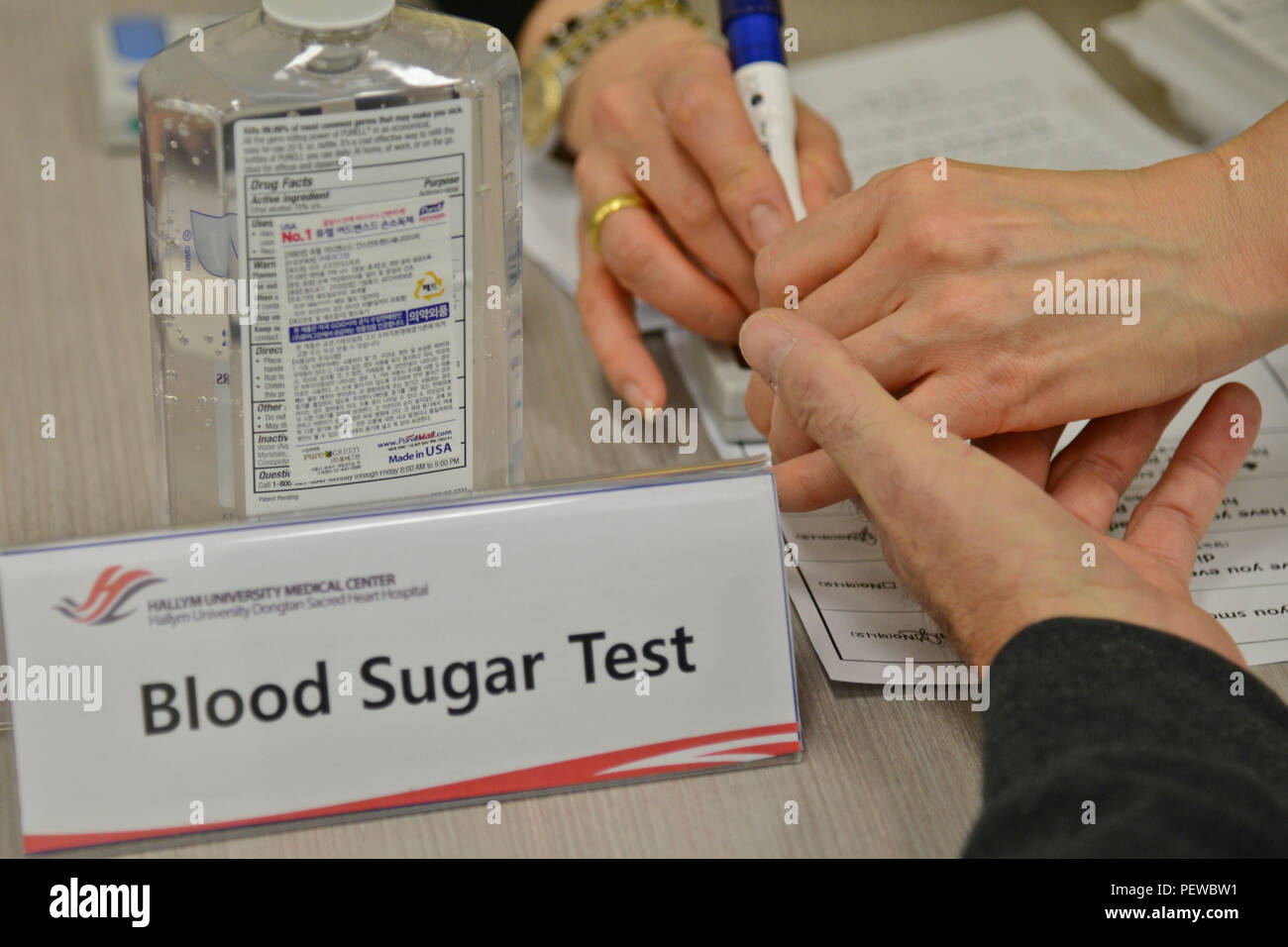 Un infermiere dall'Università Hallym Dongtan Ospedale del Sacro Cuore trafigge il dito di un pensionato per testare il suo livello di zucchero nel sangue per il diabete durante il pensionato apprezzamento il giorno in Exchange presso Osan Air Base, Repubblica di Corea, Febbraio 4, 2016. La misurazione dello zucchero nel sangue in prova è stata una delle sei stazioni disponibili per i pensionati durante la libera screening sanitario. (U.S. Air Force foto di Tech. Sgt. Travis Edwards/rilasciato) Foto Stock