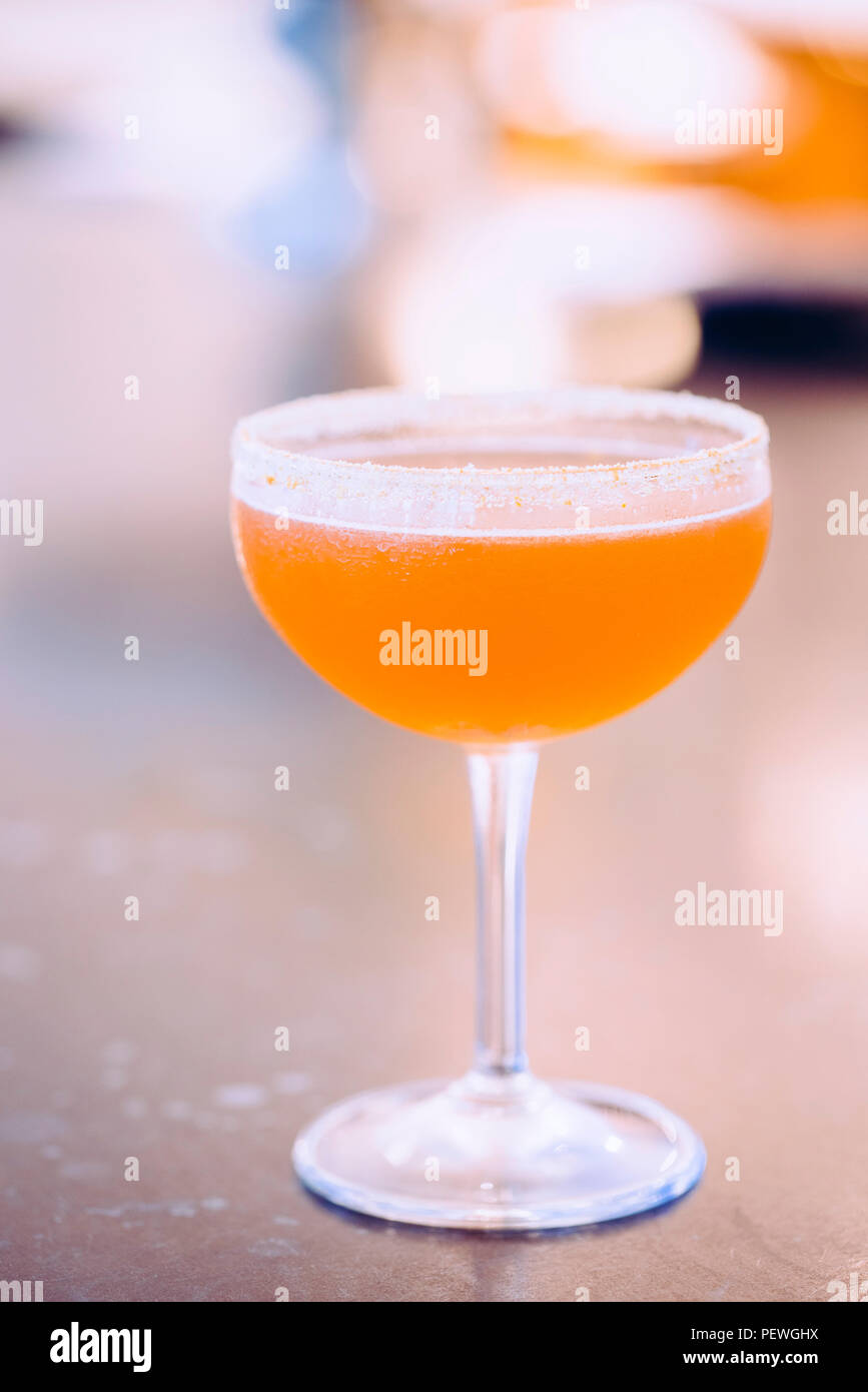 Un cocktail in un vetro di zucchero, bordo smerigliato, liquido arancione, bevande miste Foto Stock
