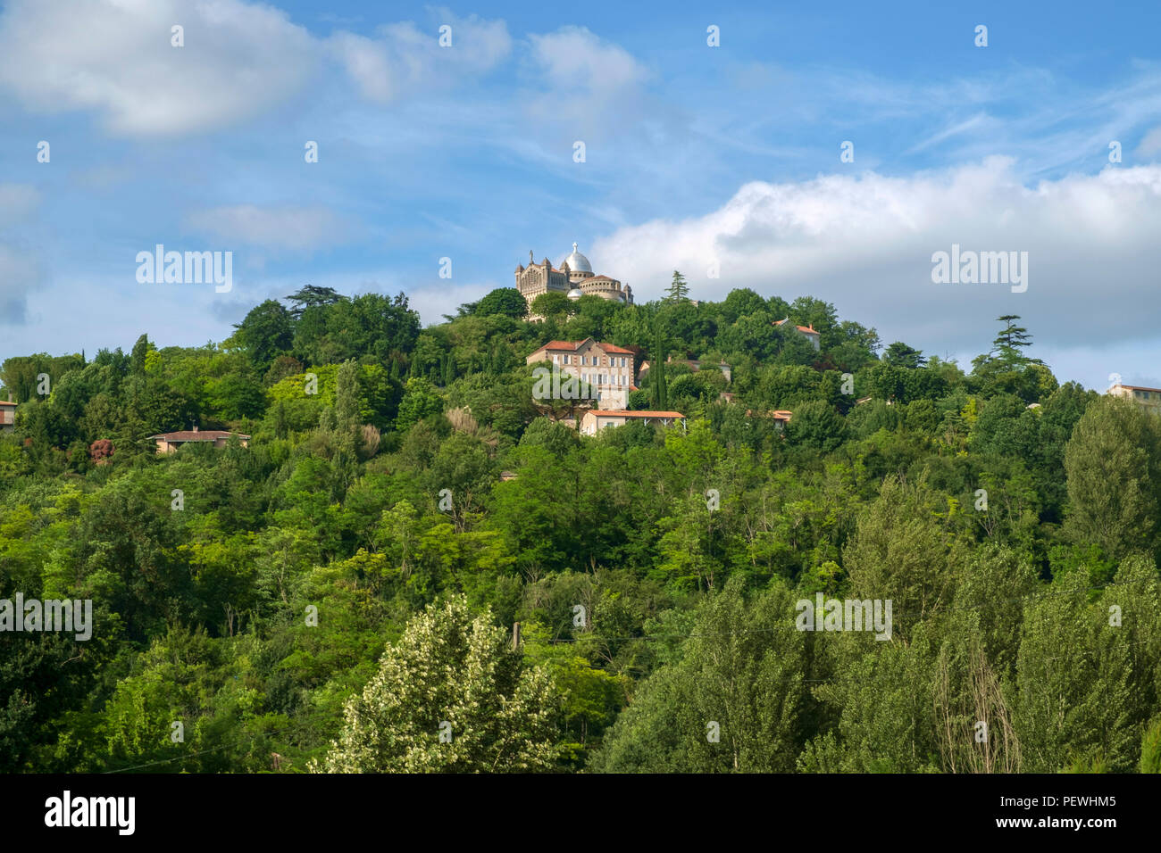 Inizio estate vista attraverso i campi di hilltop penne d'Agenais e Notre-dame de Peyragude basilica con la sua cupola di argento e Lot et Garonne, Francia. Foto Stock