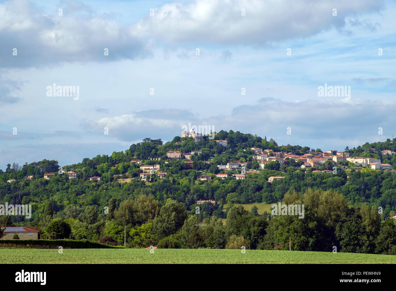 Inizio estate vista attraverso i campi di hilltop penne d'Agenais e Notre-dame de Peyragude basilica con la sua cupola di argento e Lot et Garonne, Francia. Foto Stock