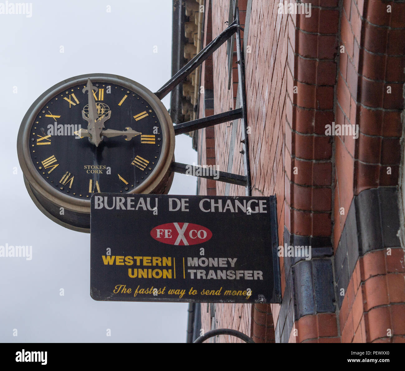 Western Union segno su un muro di mattoni rossi al di sotto di un grande orologio. Foto Stock