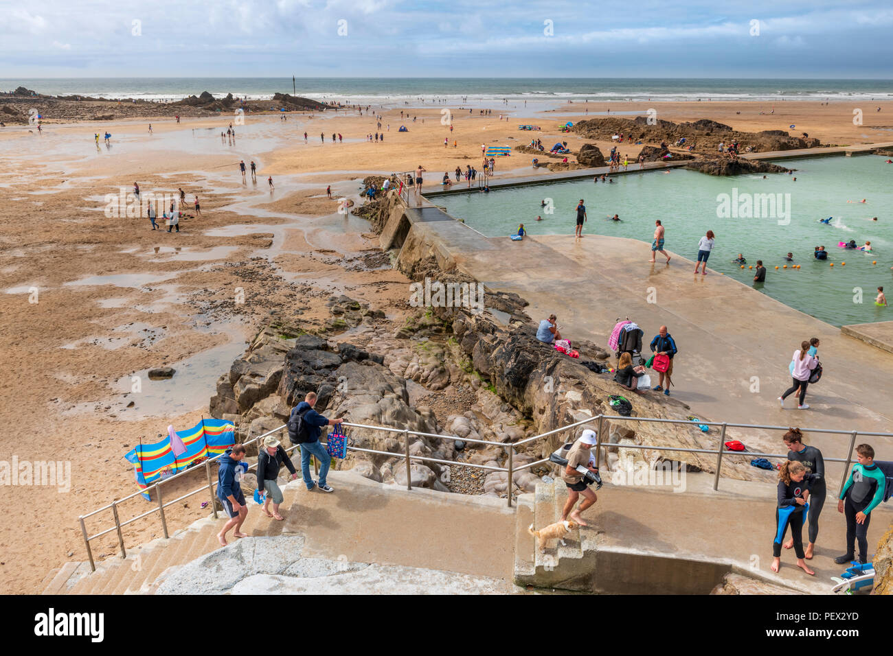 Regno Unito - Previsioni del tempo - in una giornata soleggiata di incantesimi con crescente cloud, l'aria aperta seapool sul lungomare a Bude dimostra popolare con i turisti, nonostante t Foto Stock