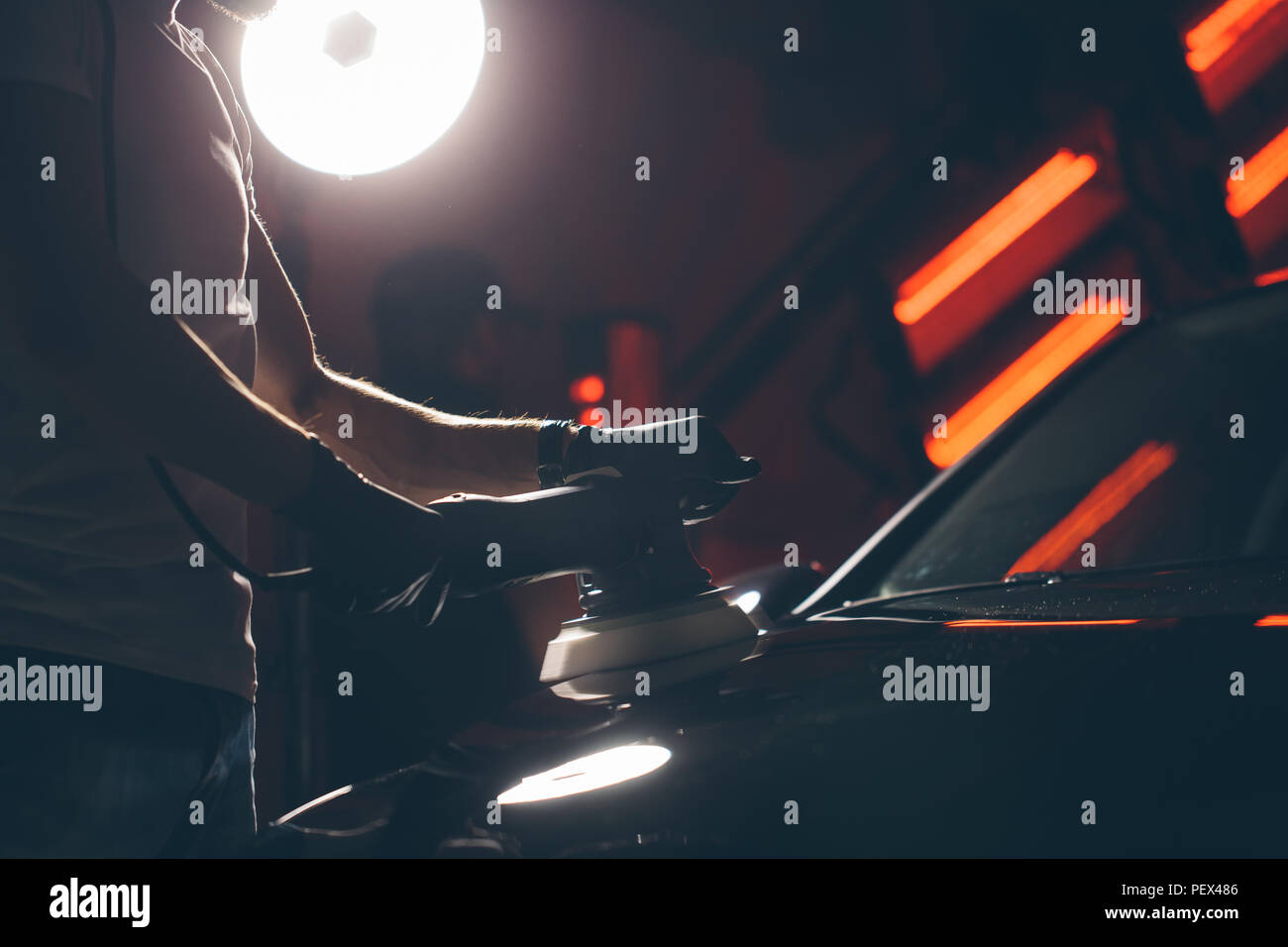 Dettagli auto - mani con lucidatrice orbitale nel negozio di riparazioni auto. Messa a fuoco selettiva. Foto Stock