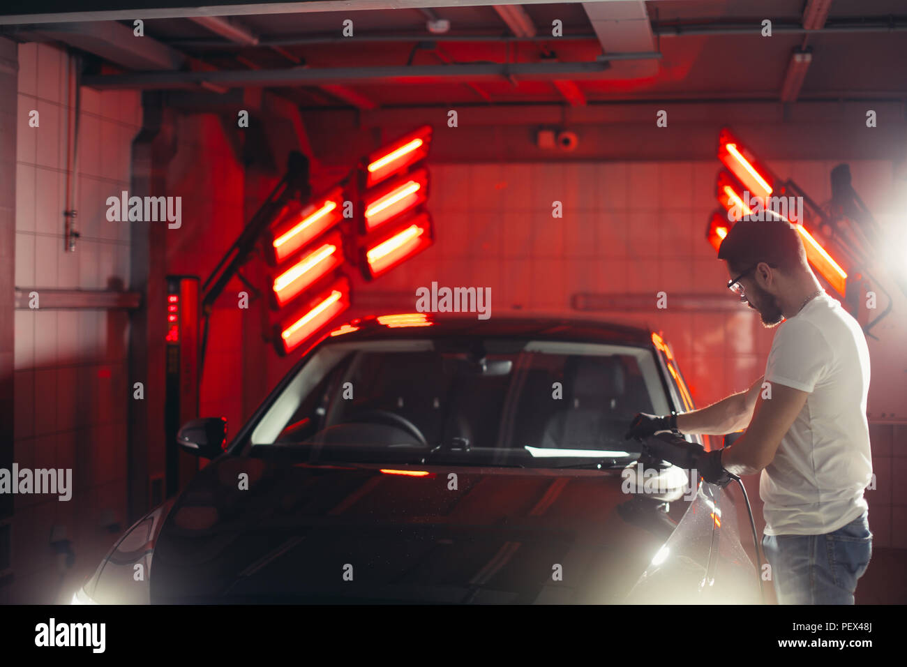 Dettagli auto - mani con lucidatrice orbitale nel negozio di riparazioni auto. Messa a fuoco selettiva. Foto Stock