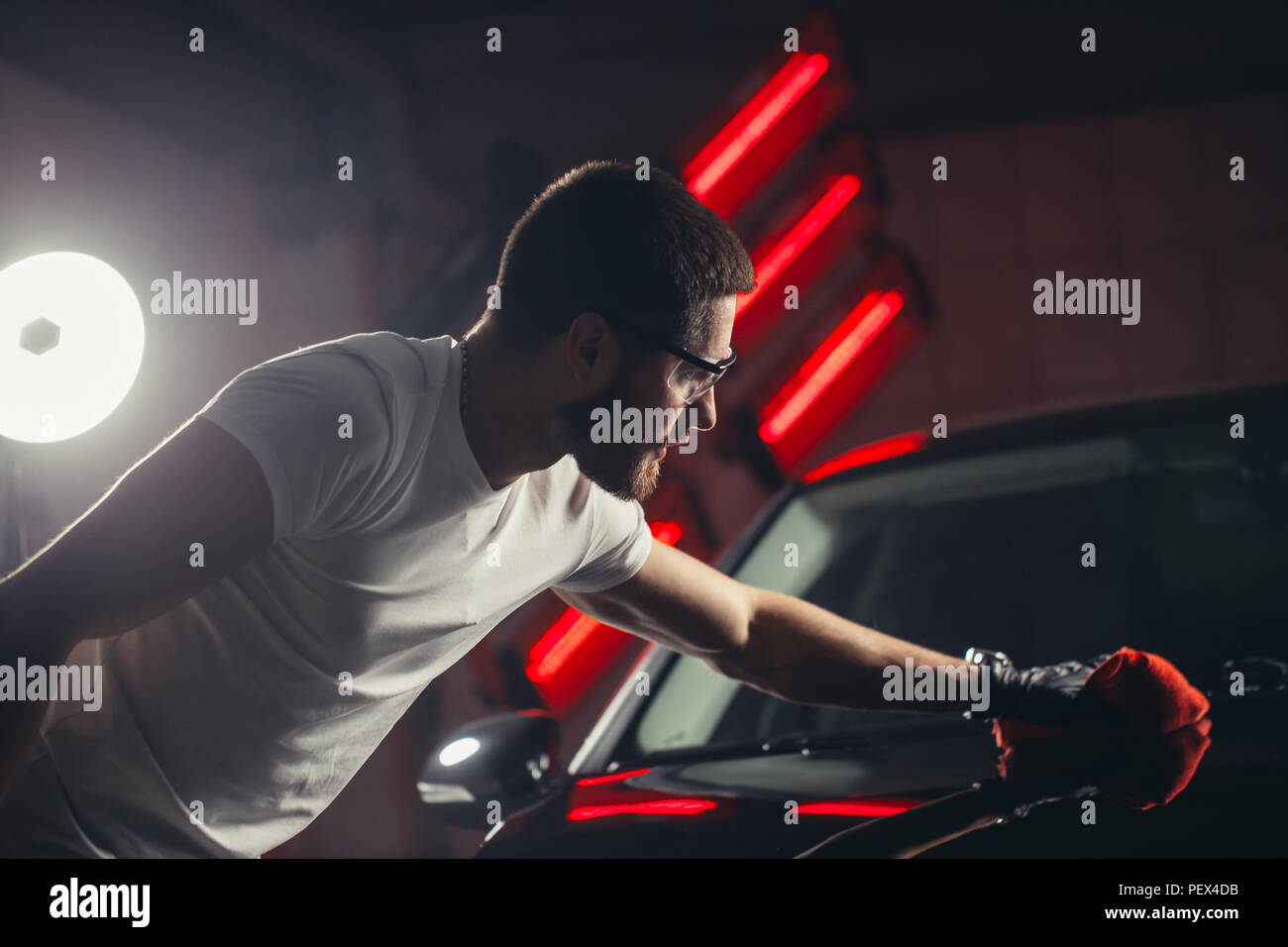 Dettagli auto - l'uomo detiene la microfibra in mano e leviga la vettura. Messa a fuoco selettiva. Foto Stock