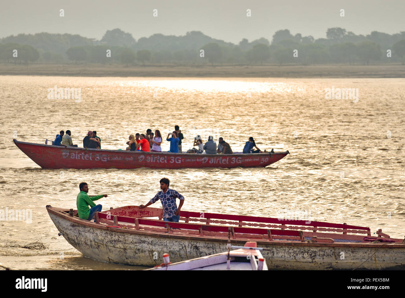 Popolo Indiano su barche sul fiume Gange al mattino con la luce dorata Foto Stock